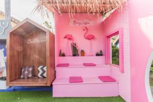 a pink house with stairs and pink flamingos at See Sky Resort in Ban Sao Thong