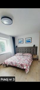 um quarto com uma cama com um cobertor floral em Pokoje Gościnne Gąsowscy Dzieci od 12 roku życia em Międzyzdroje