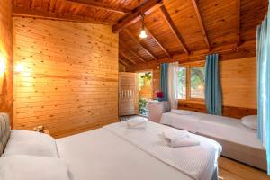 1 Schlafzimmer mit 2 Betten und Holzwänden in der Unterkunft Aylin Ahşap Evler in Yakaköy