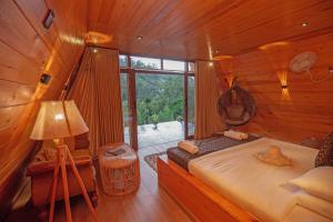 Tea Cabins في إيلا: غرفة نوم بسرير في كابينة خشبية