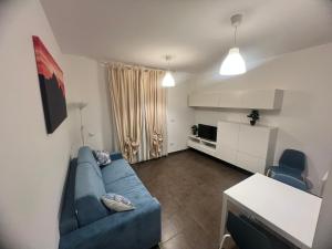 a living room with a blue couch and a kitchen at Casa Digio in Pescara