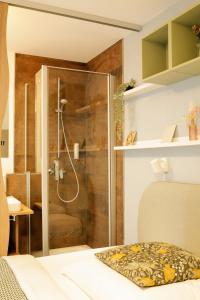 a shower with a glass door in a bedroom at R & J Hotel in Rust