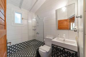 La salle de bains est pourvue d'un lavabo, de toilettes et d'un miroir. dans l'établissement Aylin Ahşap Evler, à Yakaköy