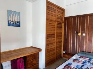 Résidence Bleu Rivage في دييجو سواريز: غرفة نوم بسرير وخزانة خشبية