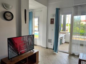 Résidence Bleu Rivage في دييجو سواريز: غرفة معيشة مع تلفزيون بشاشة مسطحة على طاولة