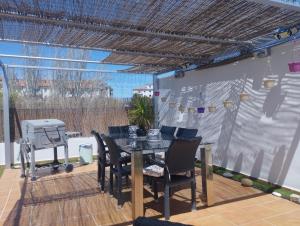 eine Terrasse mit einem Tisch, Stühlen und einem Grill in der Unterkunft Ático Rilque in Ronda