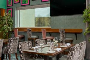 un comedor con mesas y sillas y una gran ventana en Crowne Plaza Dublin Blanchardstown, an IHG Hotel, en Blanchardstown