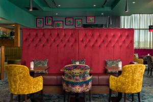 布蘭察斯鎮的住宿－都柏林皇冠假日酒店布蘭查，红色长凳,配有两张桌子和两把椅子