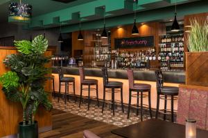 un bar con sgabelli marroni in un ristorante di Crowne Plaza Dublin Blanchardstown, an IHG Hotel a Blanchardstown