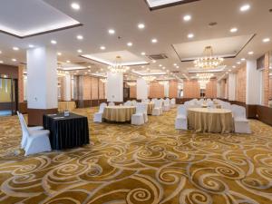 um salão de banquetes com mesas, cadeiras e lustres em Sunday Hotel Chandigarh Zirakpur em Zirakpur