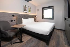a hotel room with a bed and a table and a chair at ibis Styles London Gatwick Airport in Crawley