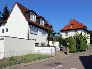 une maison blanche avec un toit rouge dans une rue dans l'établissement Haus Birkenmeier, à Fribourg-en-Brisgau