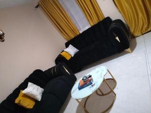 a living room with a black couch and a table at Elite stay in Embu