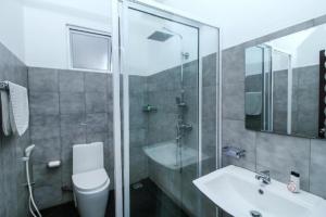 een badkamer met een toilet, een wastafel en een douche bij OYO KINGS HOTEL in Katunayaka
