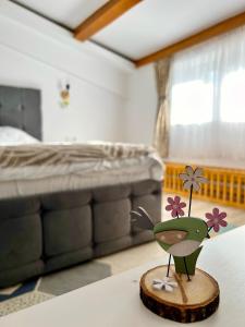 una rana giocattolo seduta su un tavolo in una camera da letto di Parc Vatra Dornei 3 - Family & couples a Vatra Dornei