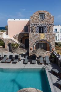 un complexe doté d'une piscine avec des chaises longues et des parasols dans l'établissement Polydefkis Hotel, à Kamari