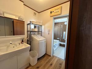 Una pequeña cocina con fregadero y refrigerador. en 近藤沢駅の新装リノベーション一軒家 3LDK、無料駐車場完備、最大7名様までご利用可能, en Fujisawa