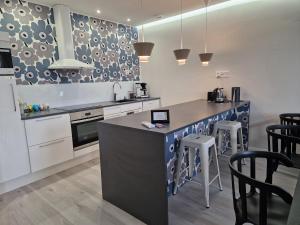 a kitchen with a counter and stools in it at Guesthouse Villa Laukkoski in Laukkoski