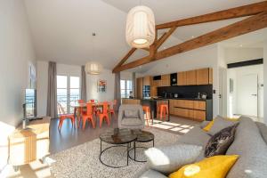 ein Wohnzimmer mit einem Sofa und einem Tisch in der Unterkunft Appartement neuf vue mer au coeur de la in La Flotte
