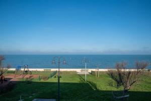 einen Blick auf einen Spielplatz mit Meerblick im Hintergrund in der Unterkunft Appartement neuf vue mer au coeur de la in La Flotte