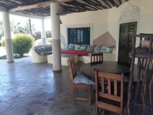 a living room with a table and chairs and a couch at Villa Simba in Galu
