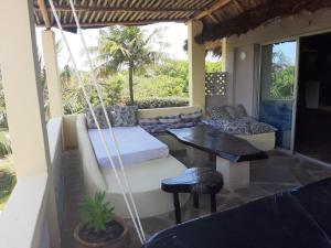een veranda met een hangmat en een tafel en stoelen bij Simba hoch2 in Galu