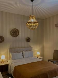 Un dormitorio con una cama grande y una lámpara de araña. en Galazia Nera Apartments, en Agios Andreas - Mesenia