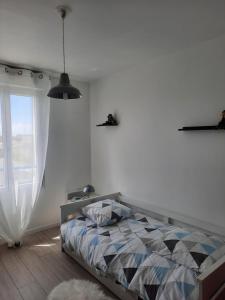 1 dormitorio con cama y ventana en Joli pavillon proximité ocean, en Saint-Nazaire