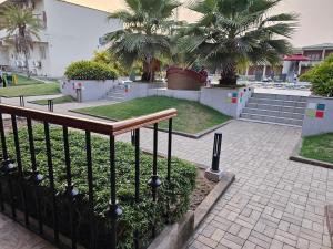 un parco con palme e una recinzione di The creek boutique resort & spa a Bolpur