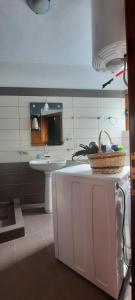 ein Bad mit einem Waschbecken und einem Korb auf der Theke in der Unterkunft Fjori's Apartment in Korçë