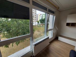 een lege kamer met twee grote ramen in een gebouw bij Apartamentos Manolo in Lugo