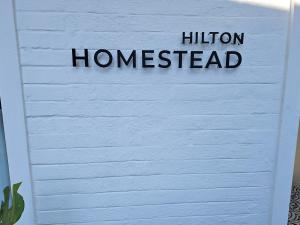 a sign for a houston homestead on a white wall at Hilton Homestead by ANEW in Pietermaritzburg