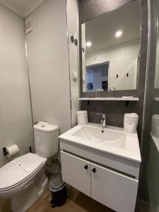 a white bathroom with a toilet and a sink at Hotel Cavaleiros De Cristo in Tomar