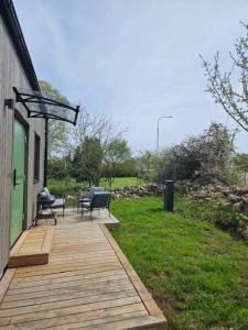 een houten terras met twee stoelen en een tafel erop bij Ebbas stuga in Färjestaden