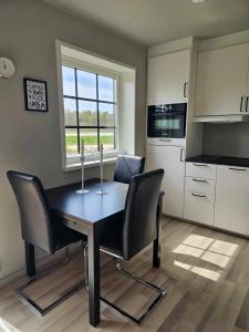 uma cozinha com mesa e cadeiras e uma janela em Ebbas stuga em Färjestaden