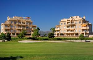 Blick auf zwei Apartmentgebäude vom Golfplatz in der Unterkunft Clavel by Oliva Nova in Oliva