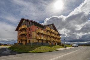 a large building with balconies on the side of a road at Tatragolf Mountain Resort F208 in Veľká Lomnica