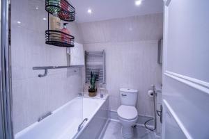 ein Badezimmer mit einer Badewanne, einem WC und einem Waschbecken in der Unterkunft Oxford Street - One Bed Lux in London