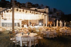 een bruiloftsreceptie met witte tafels, stoelen en verlichting bij Kempinski Hotel Barbaros Bay Bodrum in Yaliciftlik