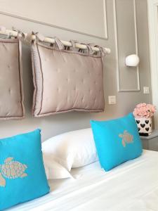 ein Schlafzimmer mit einem Bett mit blauen Kissen in der Unterkunft Villa Antonietta Ischia in Ischia