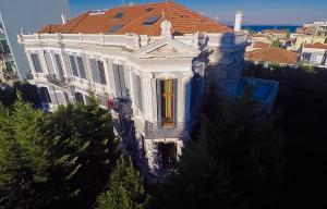 米蒂利尼的住宿－Olympias Mansion Mitilini，一座白色的大建筑,有红色的屋顶