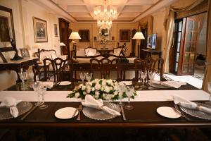 uma sala de jantar com uma mesa com pratos e flores em The Imperial, New Delhi em Nova Deli