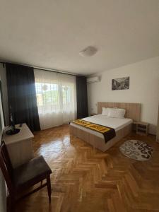 een slaapkamer met een bed en een stoel erin bij Casa RoxAmy in Orşova
