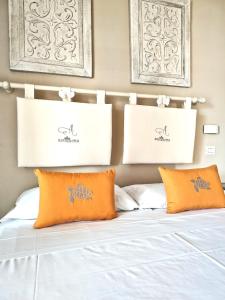a bed with orange pillows and certificates above it at Villa Antonietta Ischia in Ischia