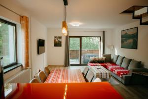 ein Wohnzimmer mit einem Sofa und einem Tisch in der Unterkunft CABANA BERNER stațiunea Mogoșa in Baia Sprie