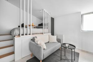 - une chambre avec des lits superposés, un canapé et une chaise dans l'établissement Magnifique studio rénové La Défense Paris Parking 2Pers, à Nanterre