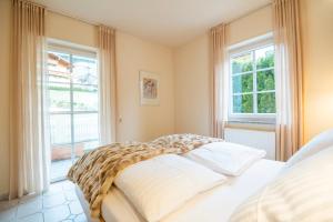 ein Schlafzimmer mit einem Bett und zwei Fenstern in der Unterkunft apart33 - Alpendorf in Salzburg in St. Johann im Pongau