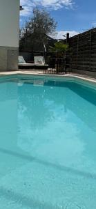 una gran piscina azul con mesa y sillas en Appartement jerry et joy, en Wolfisheim
