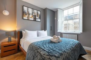 Un dormitorio con una cama con un osito de peluche. en Baker st / Marylebone / Sherlock Holmes 3Bed2Bath, en Londres