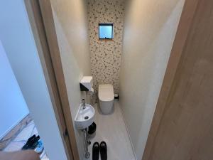 a small bathroom with a toilet and a sink at Dia INN in Sumoto